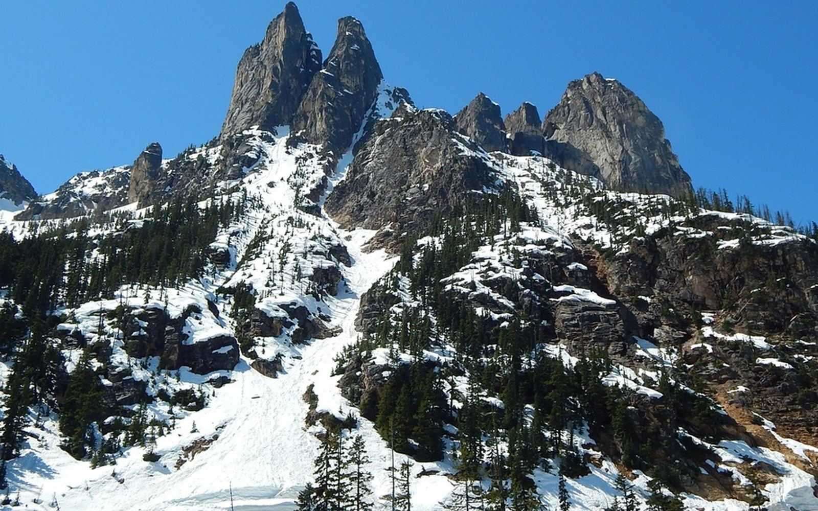 Snow-covered slopes lead up to the jagged rock spires of Early Winters Spires