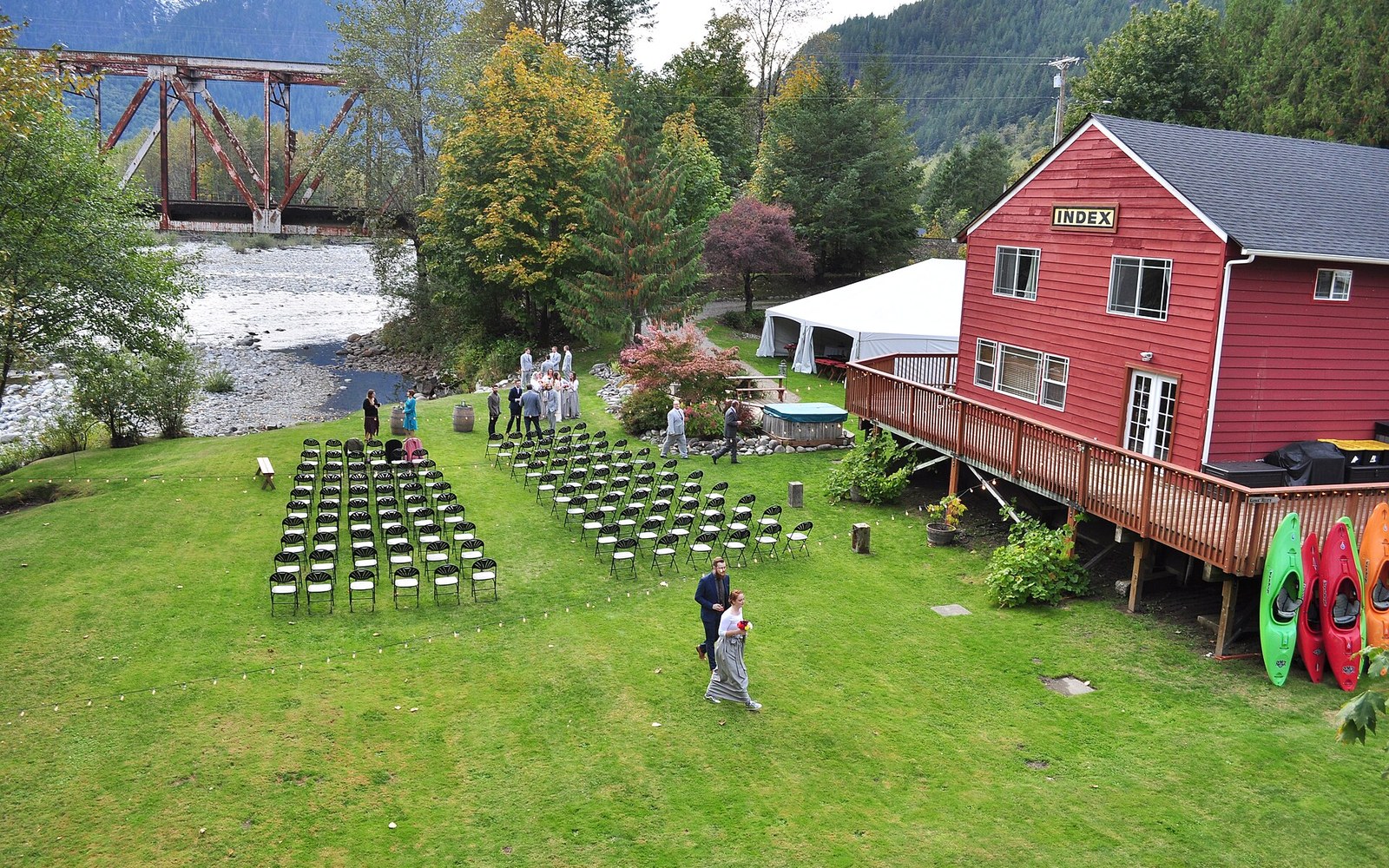 Rows of empty chairs set up for an outdoor wedding beside the Index building and river